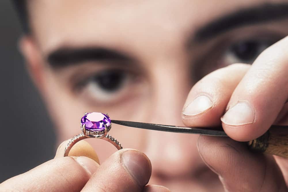 Man examining an amethyst ring.