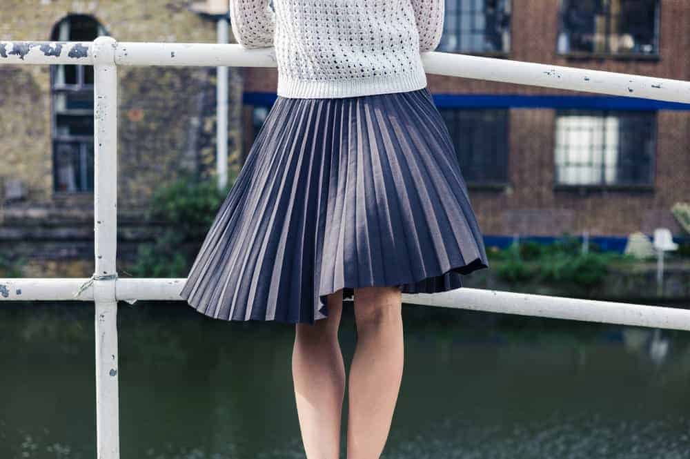 Woman on a bridge wearing an asymmetrical skirt.