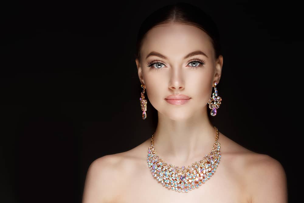 Woman wearing necklace and matching earrings.