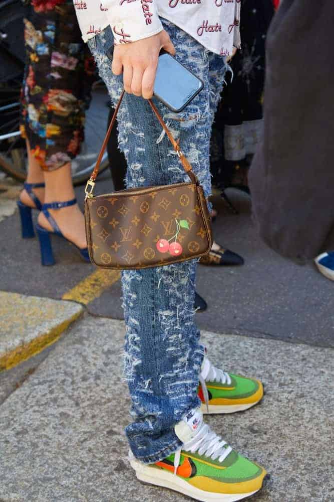 Woman with Louis Vuitton bag and Nike sneakers.