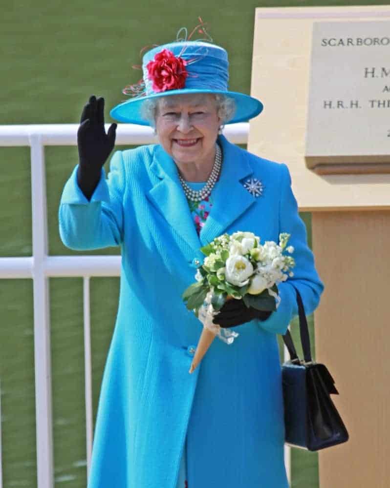 Highness Queen Elizabeth II carrying a black leather handbag.