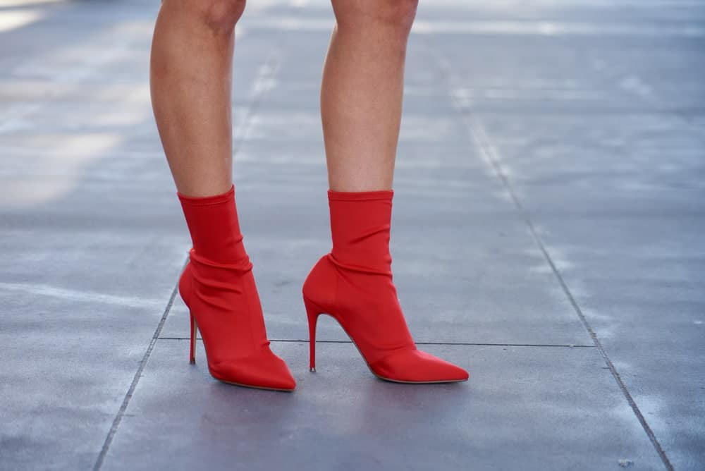 Woman on pavement wearing red sock ankle boots.
