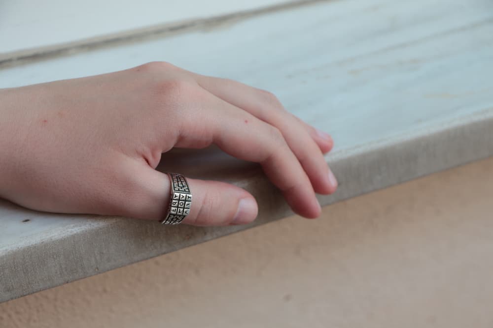 Hand with silver thumb ring.