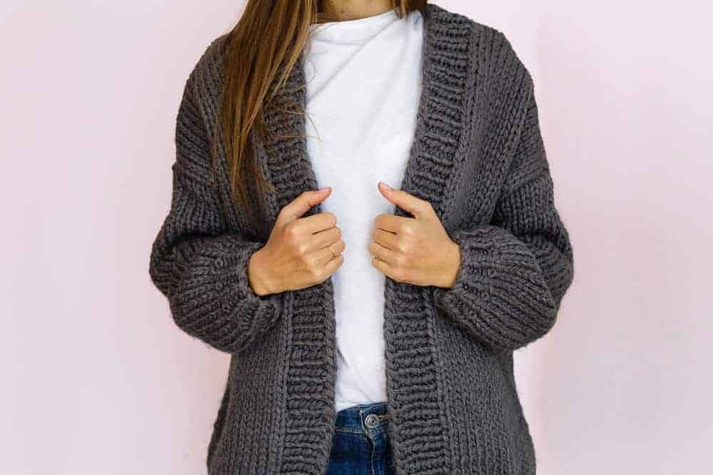 A woman wearing a gray knit cardigan.