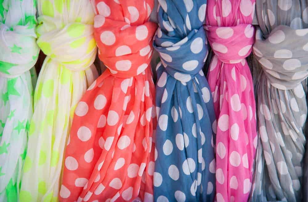 A row of colorful, dotted cotton scarves.
