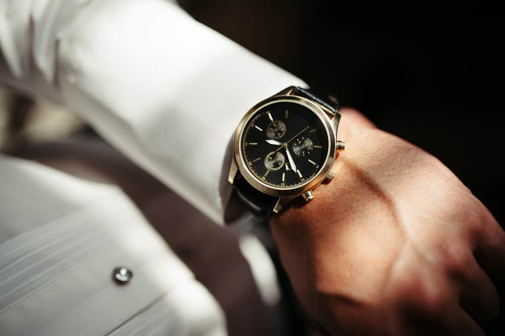 An elegant analog dress watch on a formally-dressed man.