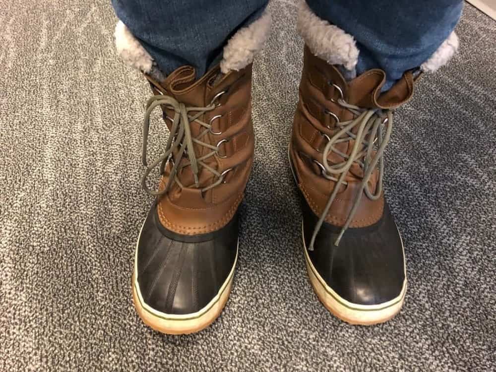 Sorel Caribou boots laced up worn with jeans.