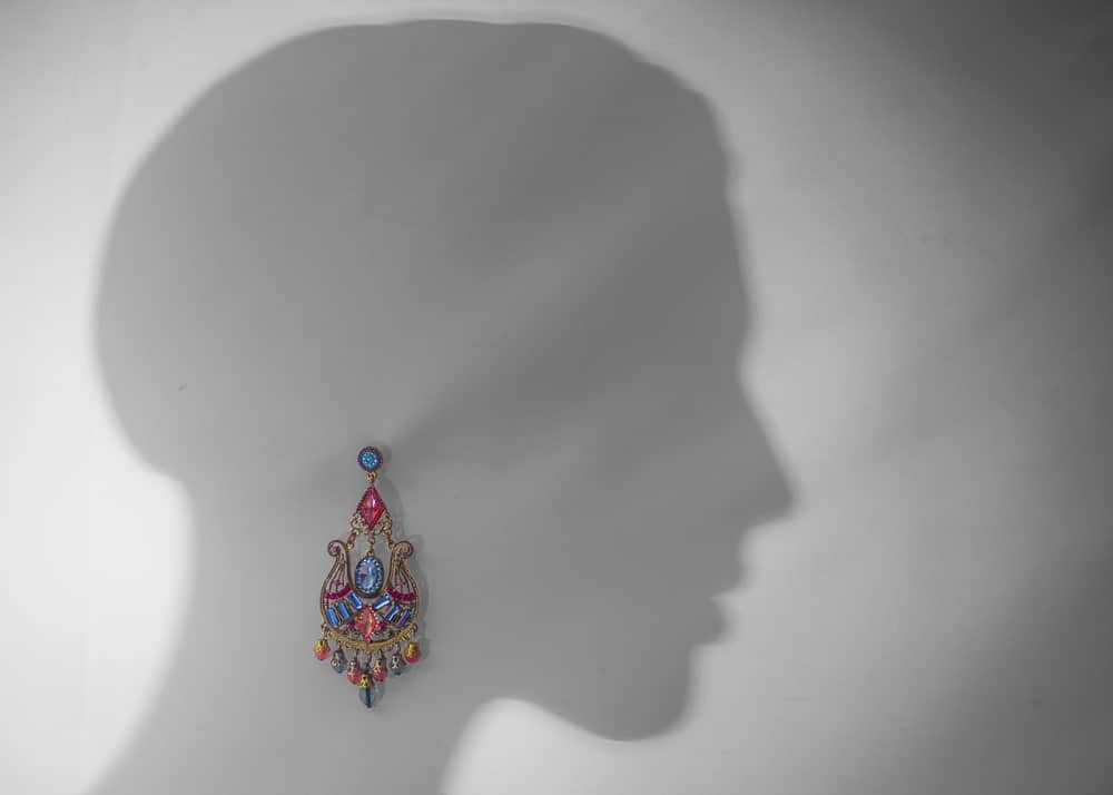 A silhouette of a woman with a colorful earring on it.