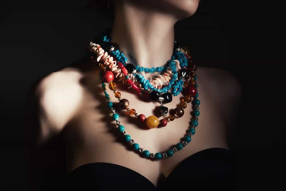 A close look at a woman wearing various bead necklaces.