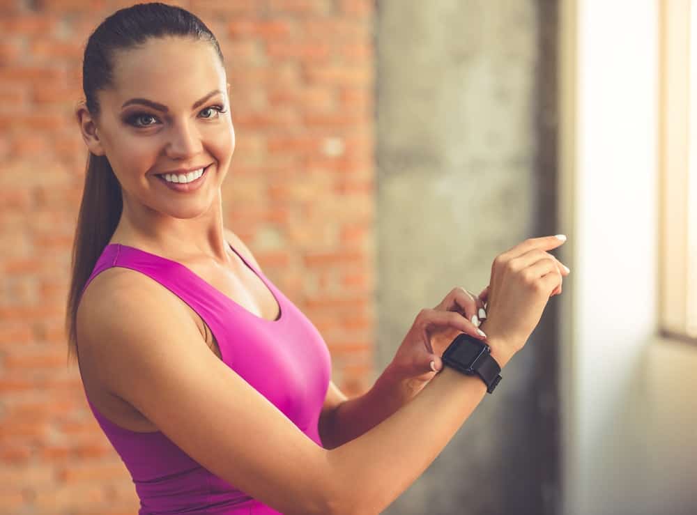 A woman adjusting her Fitbit before exercising.