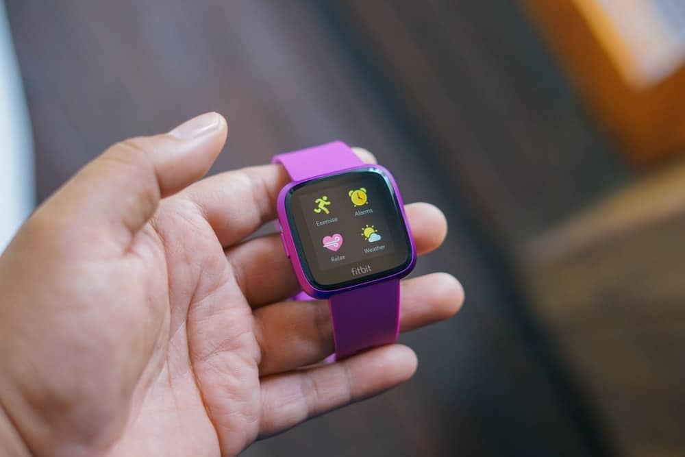 A close look at a Fitbit with purple straps.