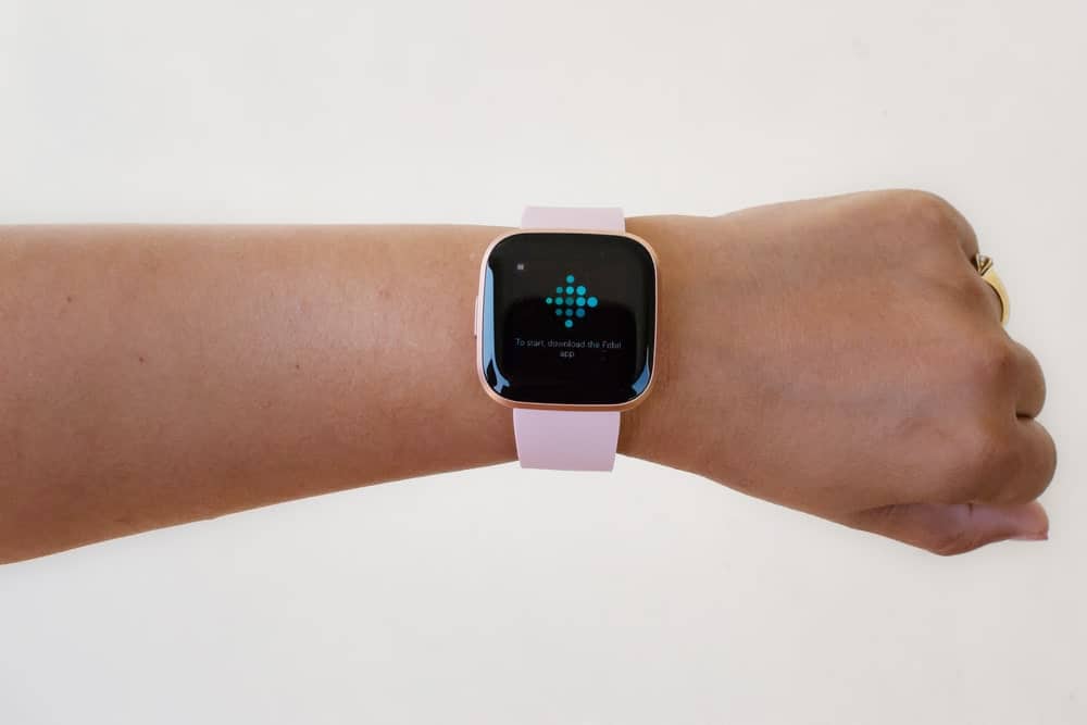 Woman hand wearing a Fitbit smartwatch.