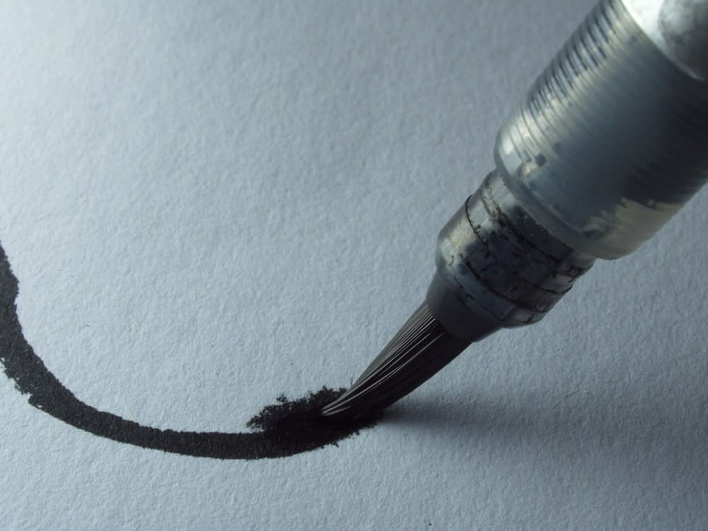 A close look at a Fude brush pen as it writes on a piece of paper.