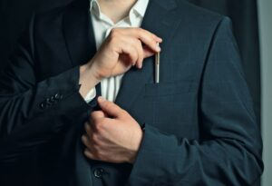 Close up of person sliding a pen into suit jacket pocket