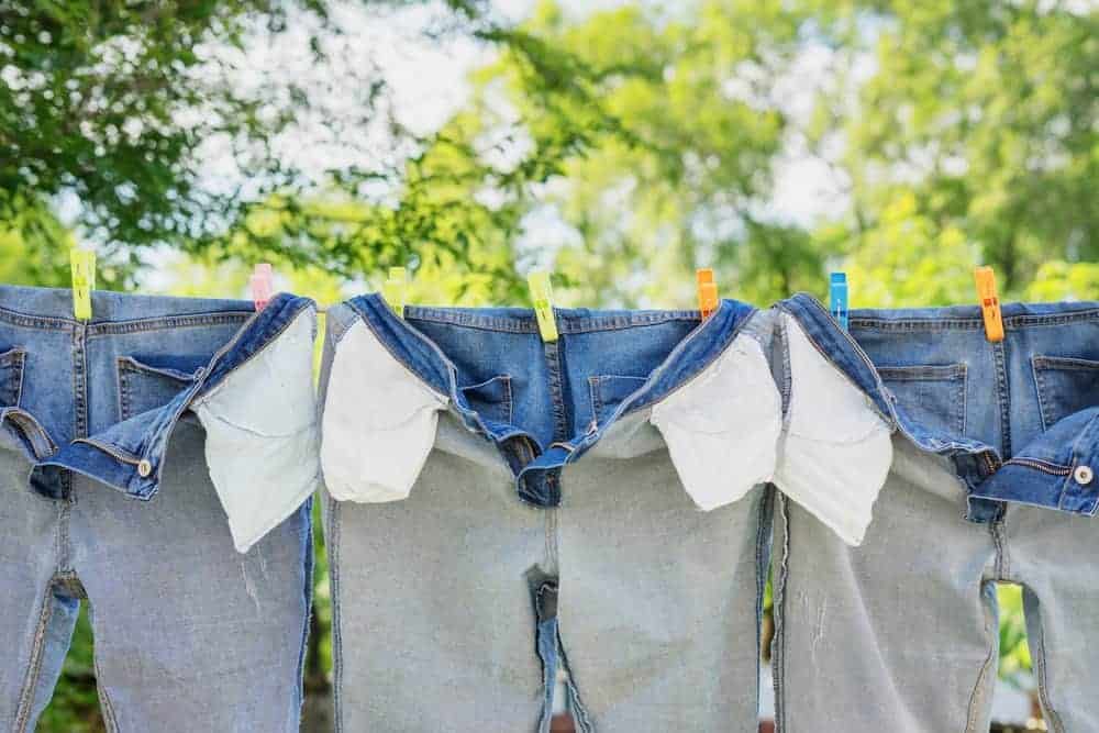 Pairs of inside-out jeans that are hanging on a clothes line.