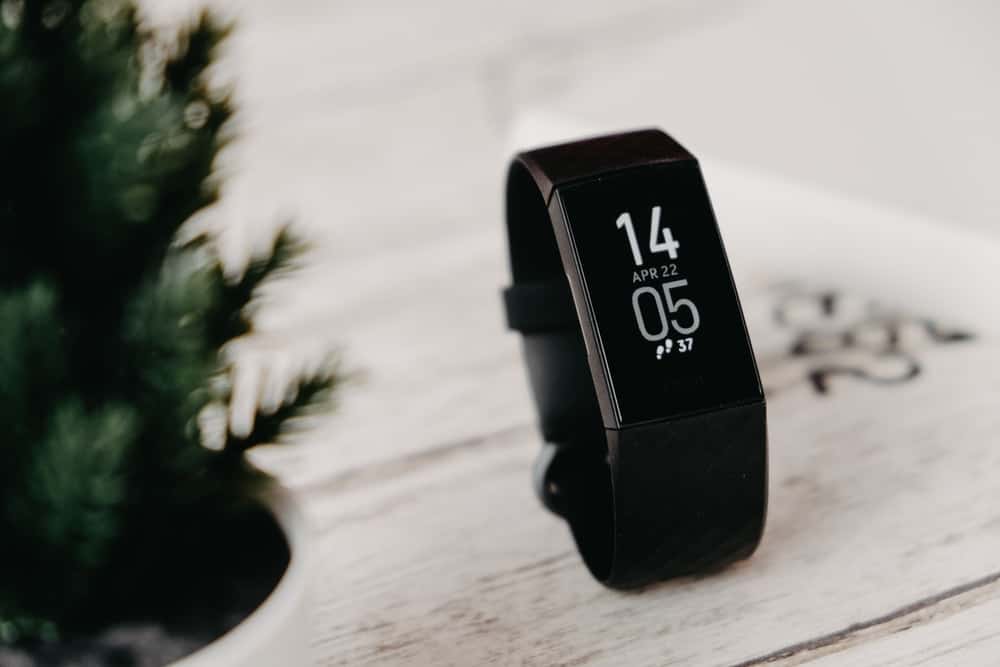A close look at a brand new Fitbit on a wooden surface.