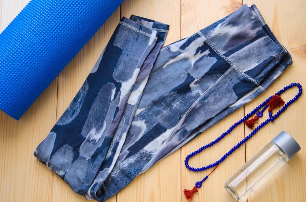 A look at a pair of yoga pants, a yoga mat and a water bottle.