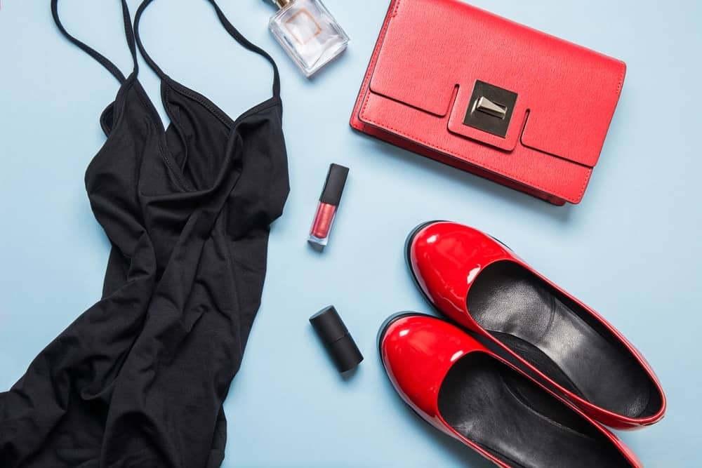 A close look at an outfit set with red accessories, red shoes and a little black dress.