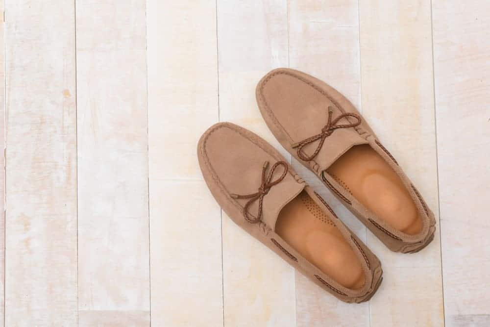 A pair of brown loafers on a wooden floor.