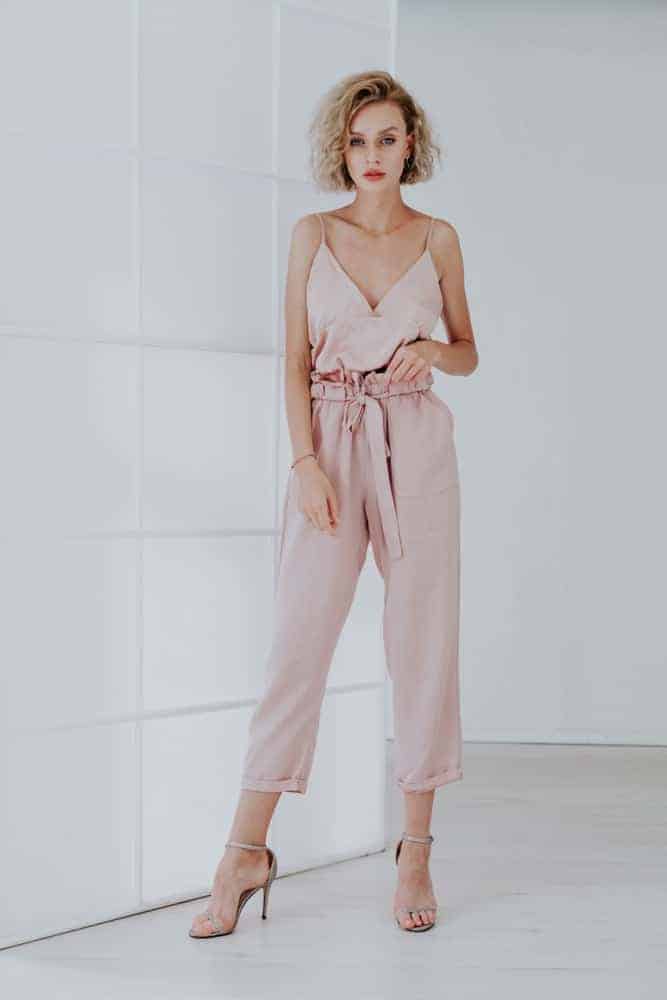A woman wearing a pair of fashionable pink jumpsuit.