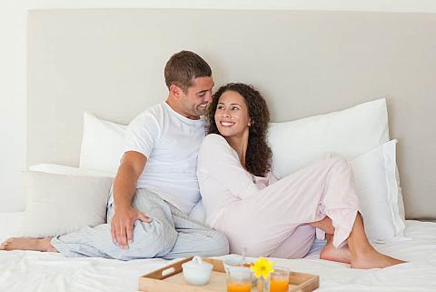 Man and woman in bed wearing pajamas