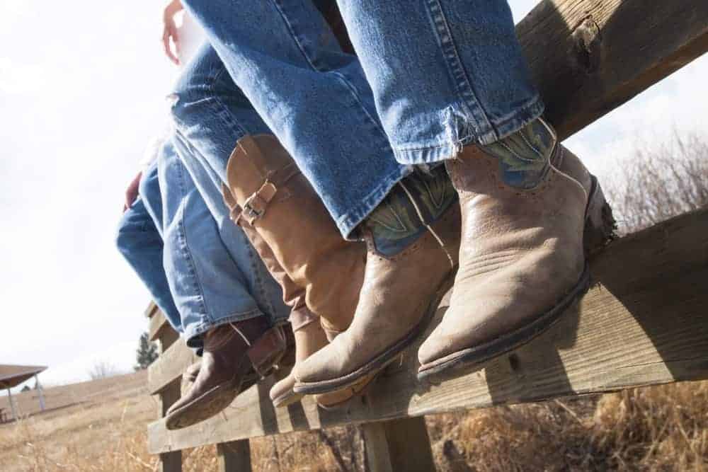 A row of cowboys wearing jeans and boots.