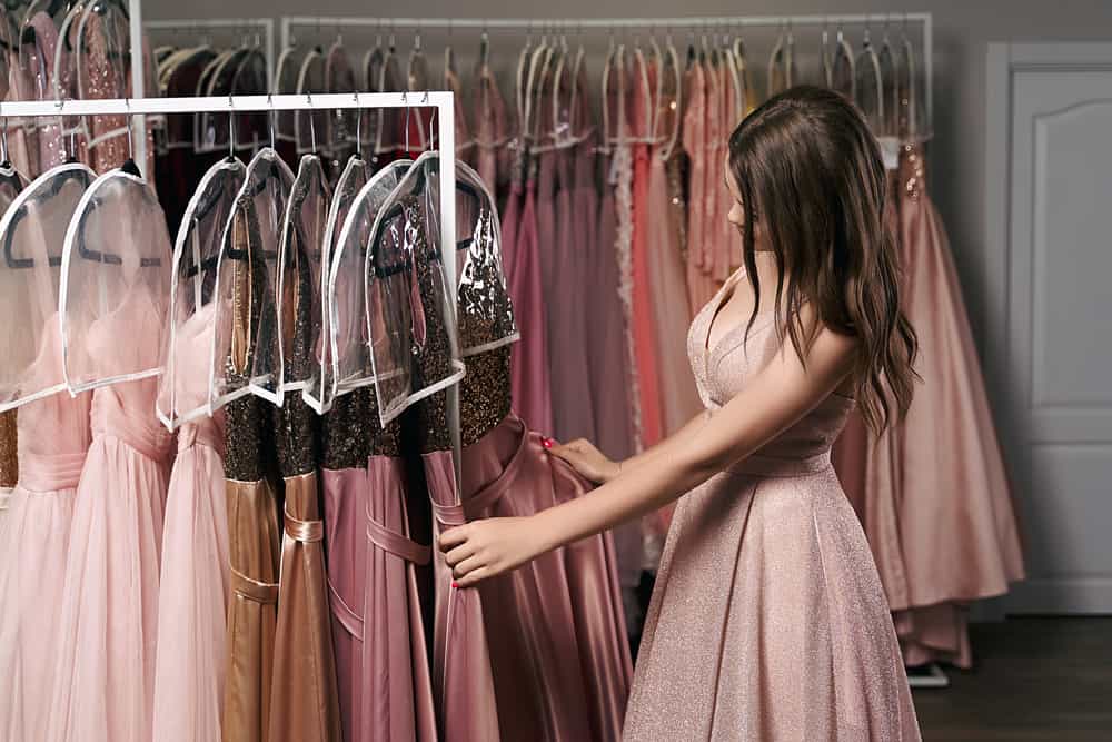 Model in a dressing room selecting an outfit.