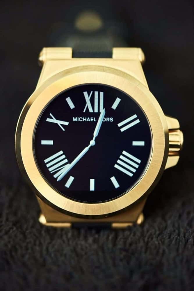Michael Kors gold smartwatch with black watch face.
