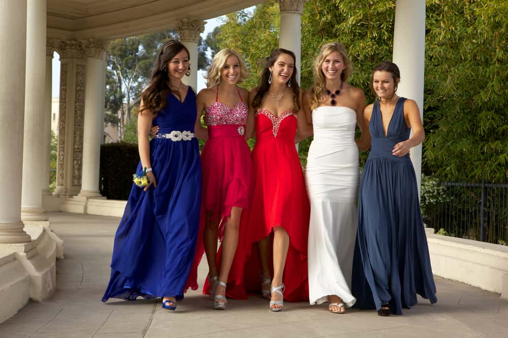 Teenage girls walking in their prom dresses.