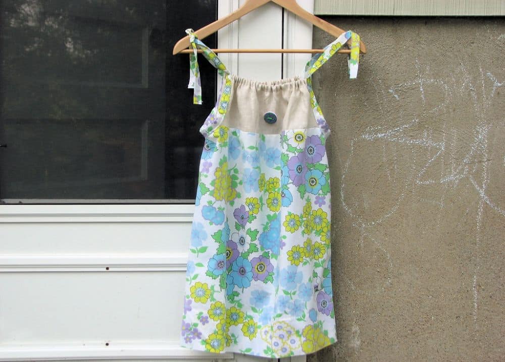 A pillowcase dress with floral print in a hanger.