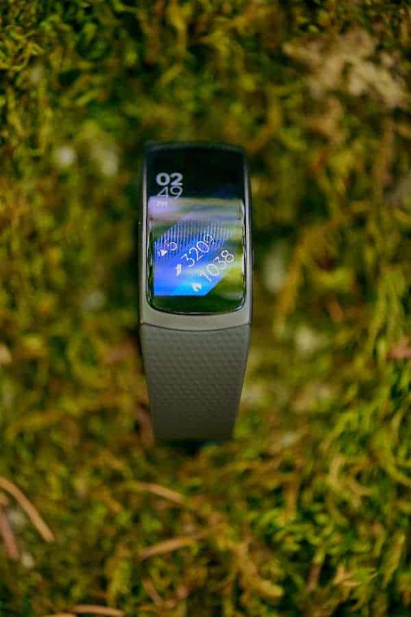 A close look at the Samsung Gear Fit 2 Smartwatch on a grass lawn.