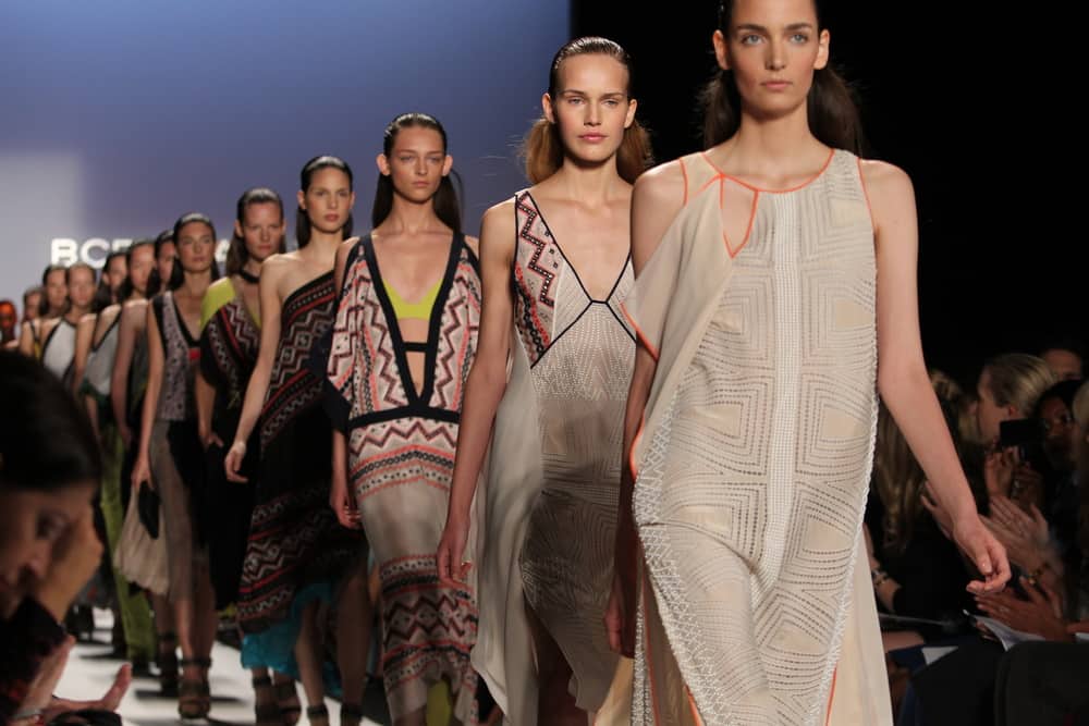 Models walk the runway in a runic dress.