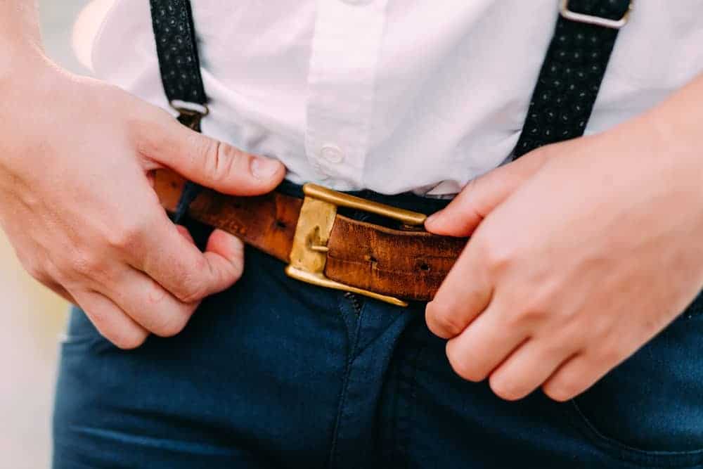 A close look at a man sporting a brown leather belt.