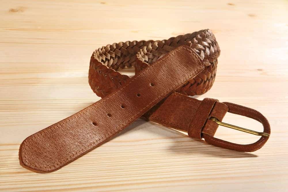 A close look at a brown leather braided belt.