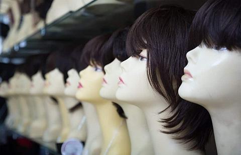 A row of wigs with bangs on display.