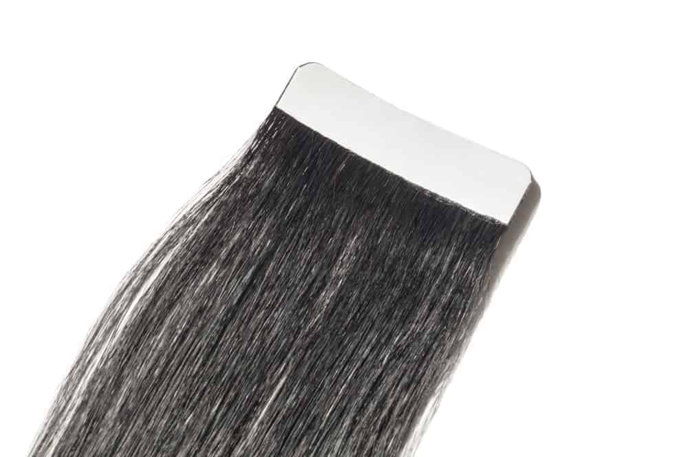 Tape in pre-bonded straight black human hair extensions.