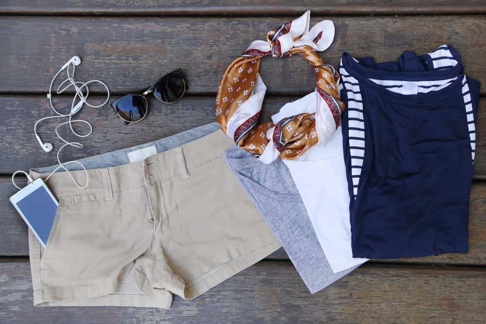 A cool outfit with shirts, a scarf and a pair of khaki shorts.