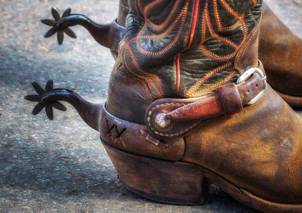 A close look at a pair of cowboy boots with spurs.
