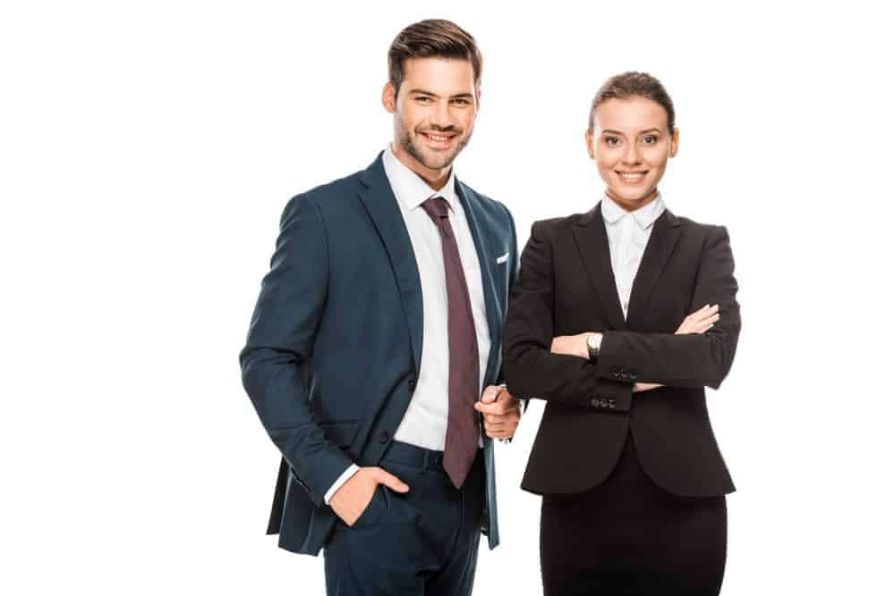 A man and a woman wearing dark toned suits.