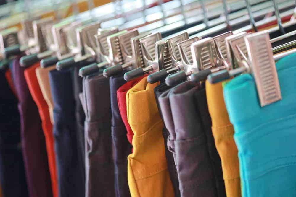 A close look at a rack of various colorful trousers.