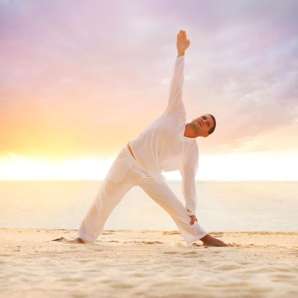 A man wearing yoga pants at the beach.