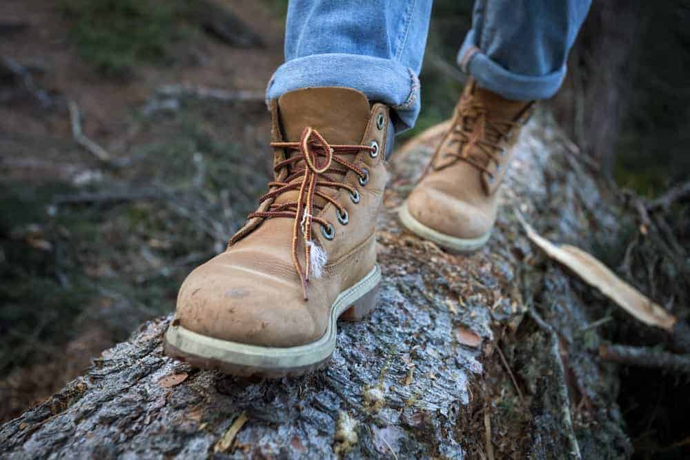 A man on a hike wearing a pair of brown hiking shoes.
