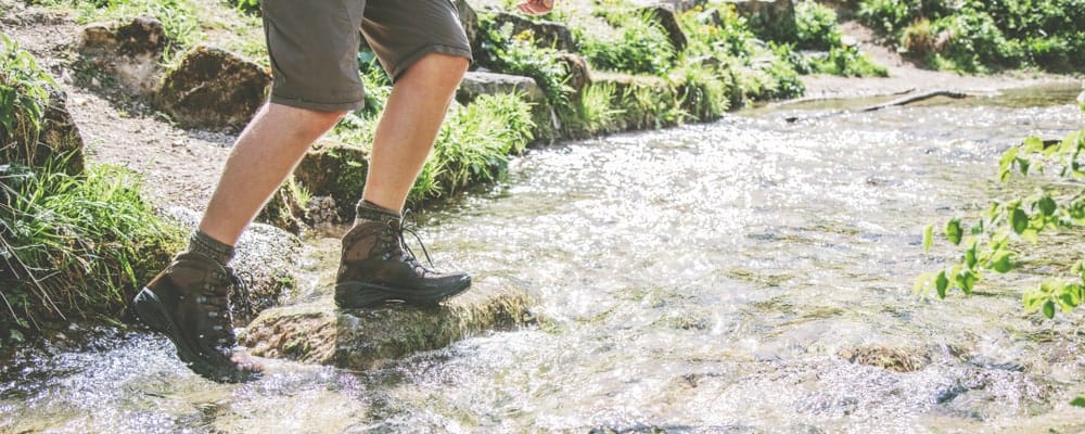 A man on a hike wearing water-proof boots.