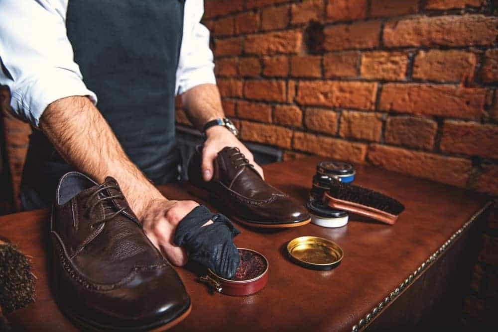 This is a close look at a man polishing his leather shoes.