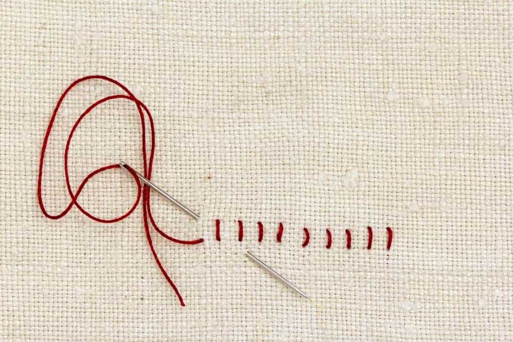 A close look at stitches on a piece of cloth.