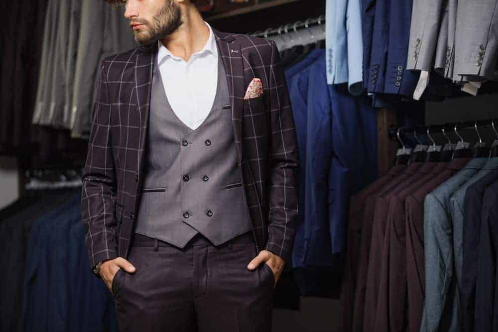 Man in a boutique wearing a classic plaid suit.