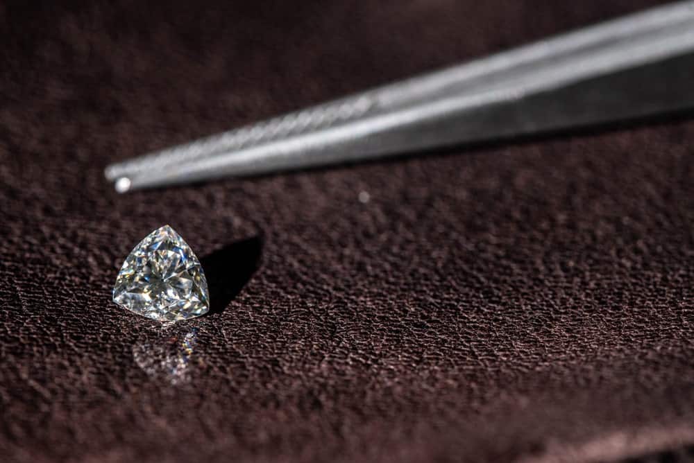 This is a close look at a single trillion cut diamond with a pair of tweezers.