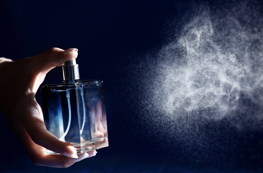 This is a close look at a woman spraying perfume.
