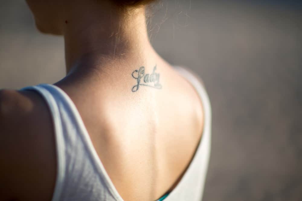 A close look at the back of a woman with a tattoo depicting the word "lady".