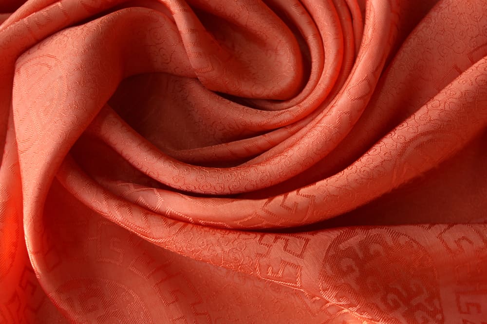 This is a close look at a bright-toned brocade fabric with patterns.